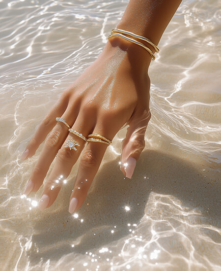 Main avec bijoux dans la mer
